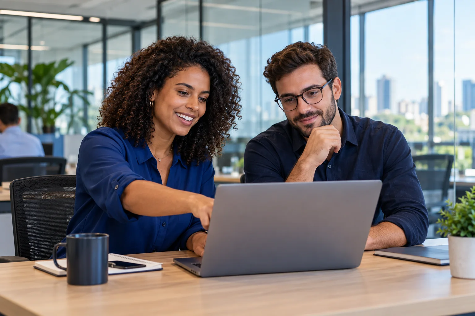 Profissionais analisam a operação de uma empresa em um notebook.